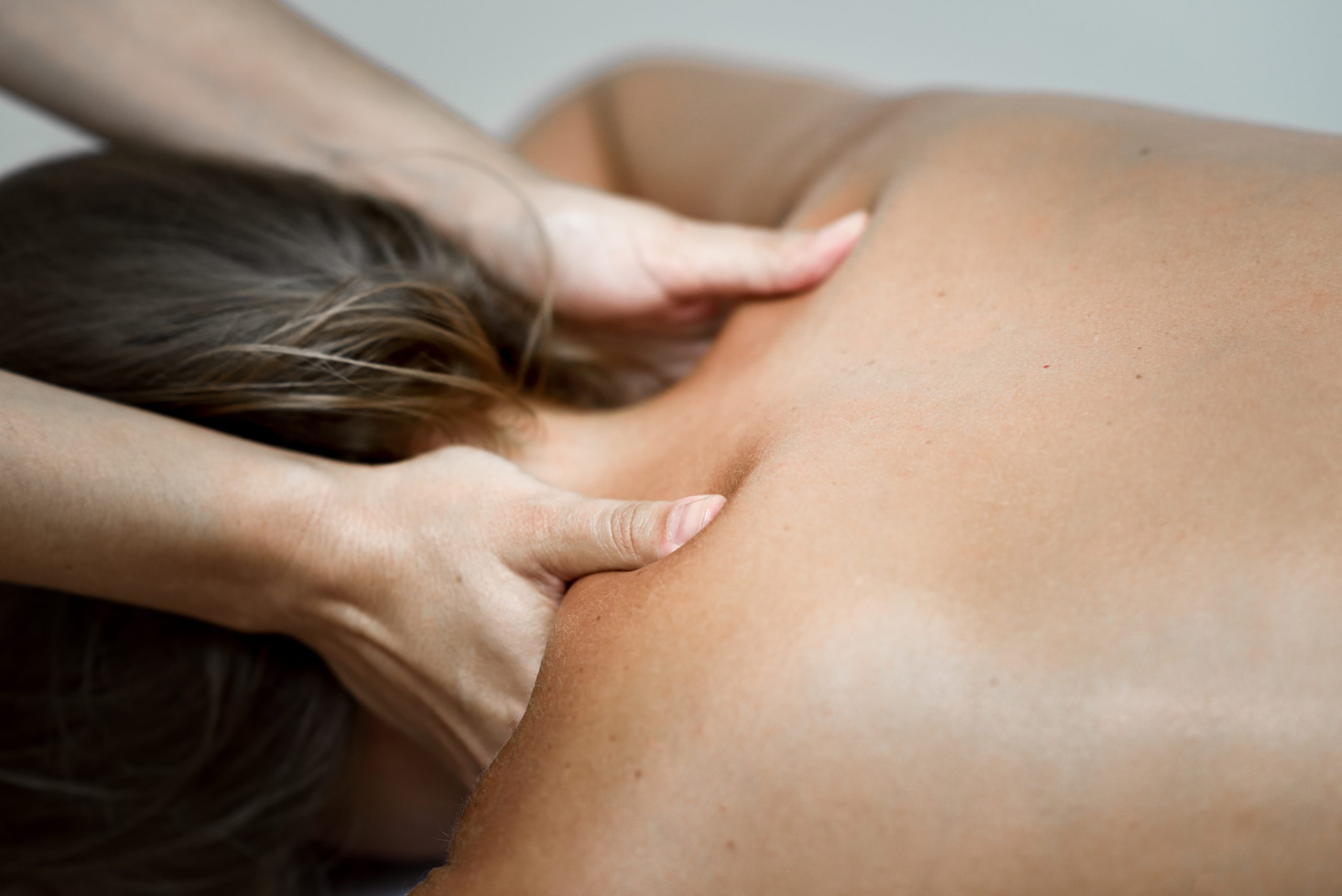 Young woman receiving a back massage in a spa center. young-woman-receiving-back-massage